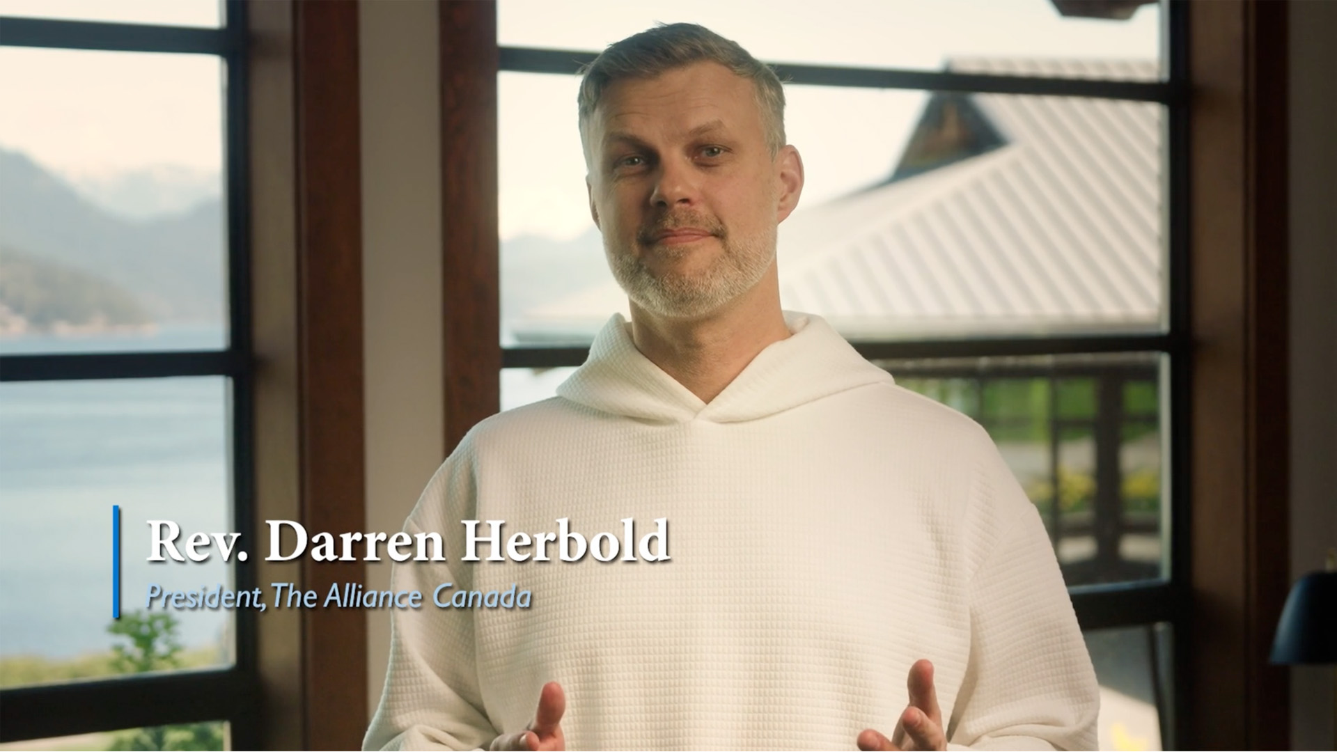 Darren standing in front of a window at Barnabas Landing BC, speaking toward the camera