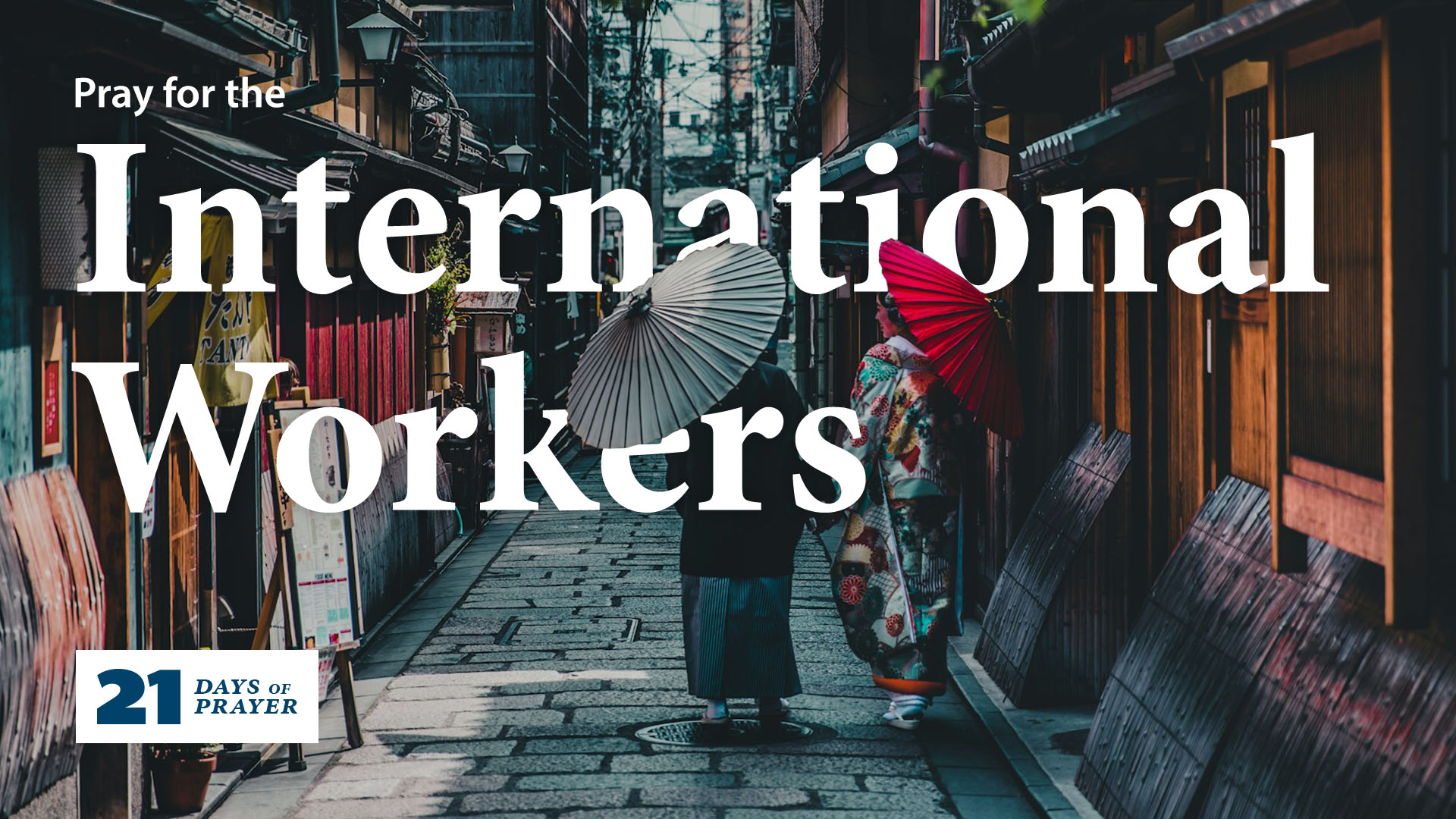 People walking on the street in Japan while wearing traditional clothes and holding paper sun umbrellas.