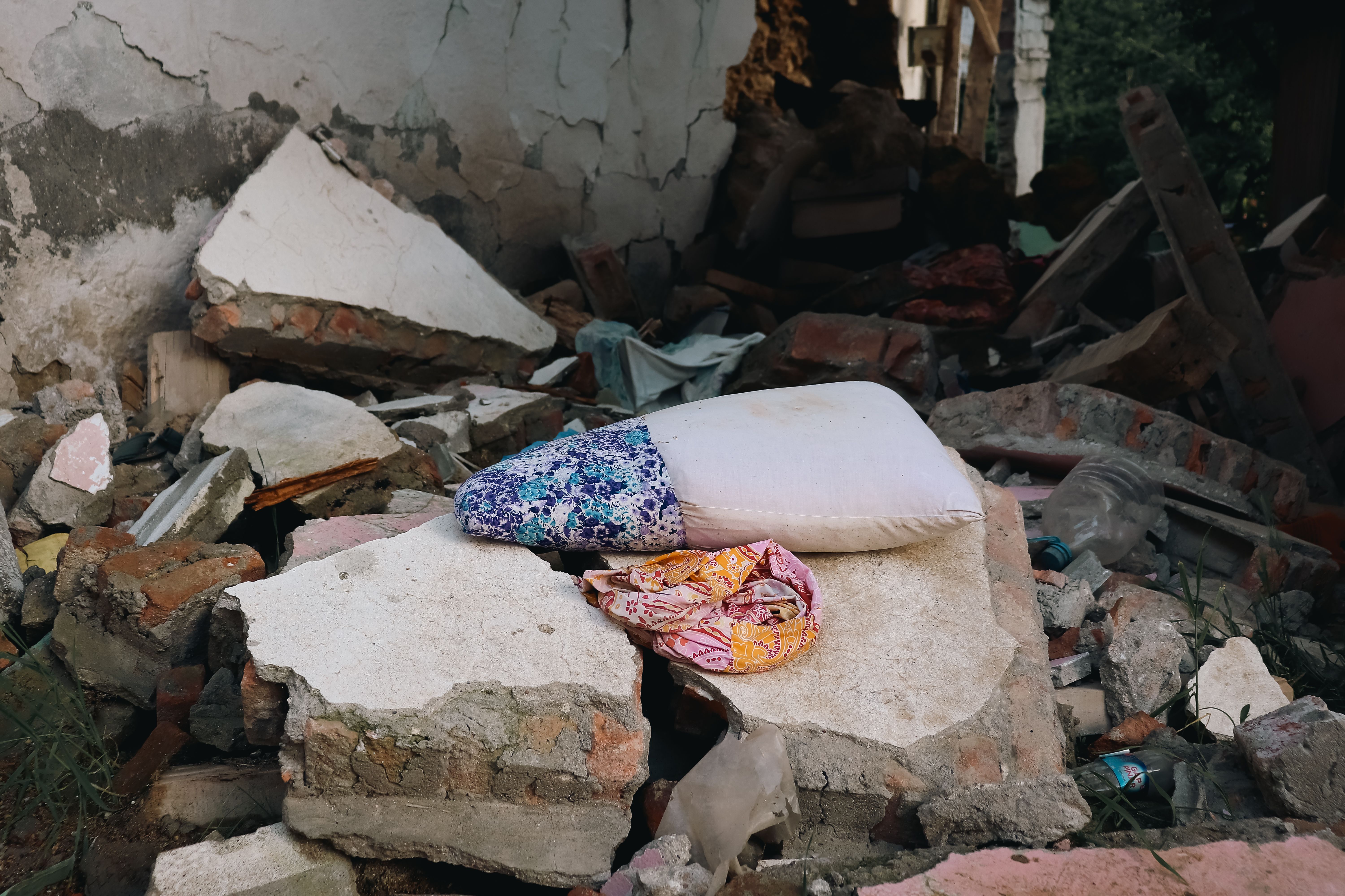 Two pillows resting on rubble from an earthquake